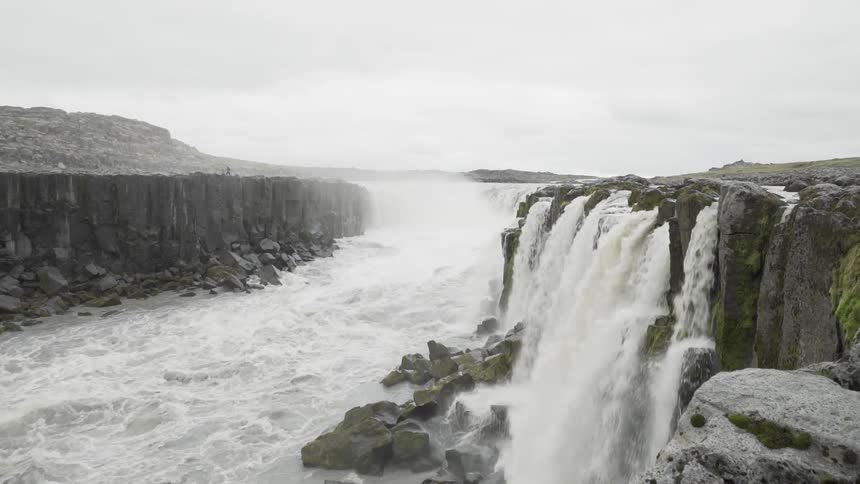 Aerial view of mountains and waterfall is displayed