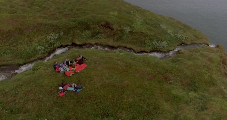 People sitting next to a brook