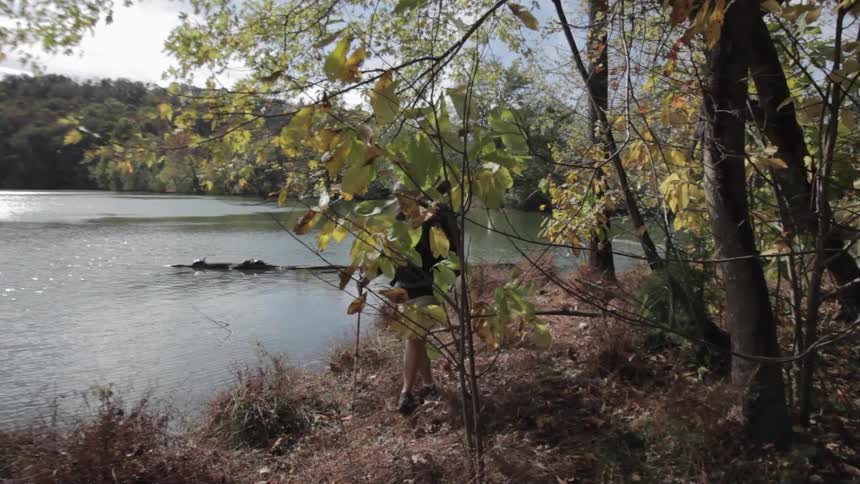 Young man hiking beside a lake on a fall day