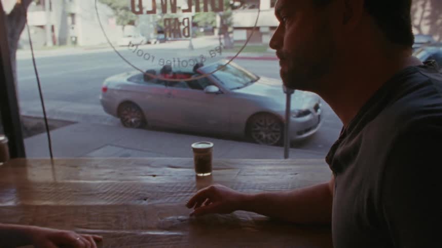 A woman entering a city building and approaching a man