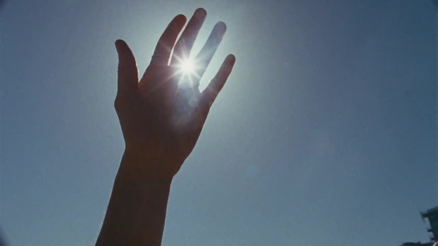 A woman outstretching her hand in sunlight