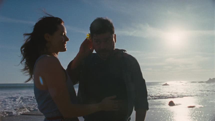 A man and woman meet on the shore and share a loving moment