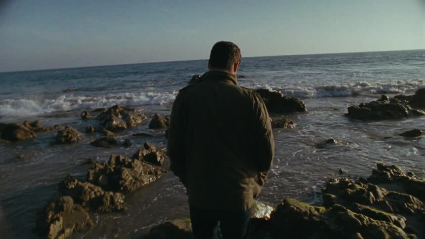 A man walking on a rocky beach