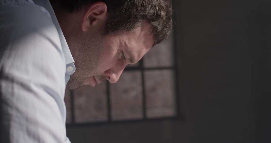 A man staring downward intensely