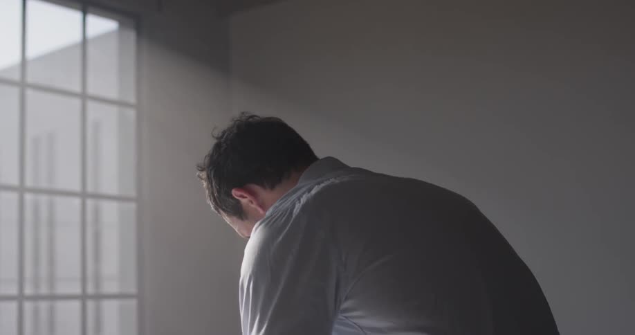 A man leans over by the window