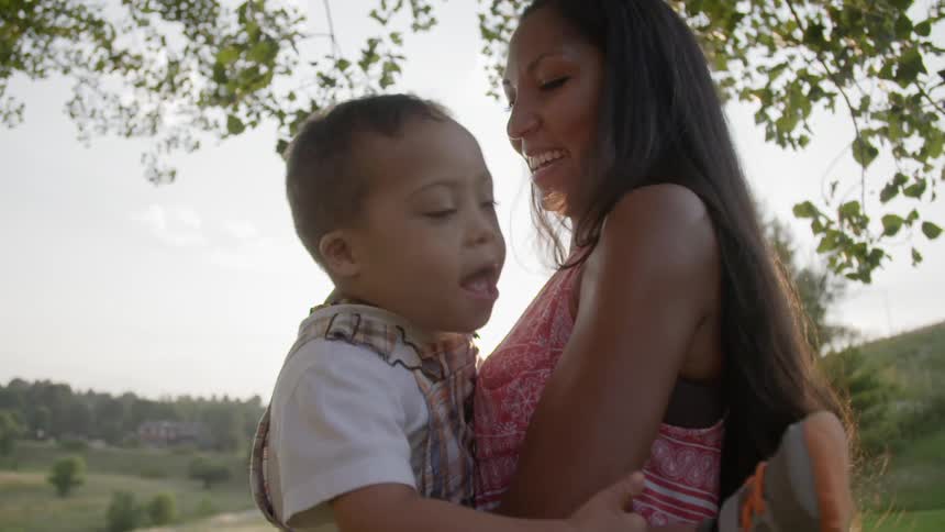 A woman holding a toddler outside