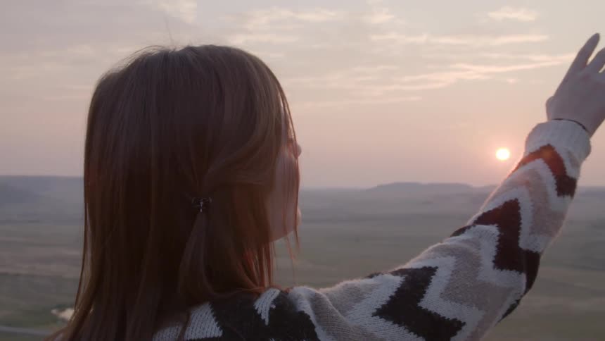 A woman is looking at the sun