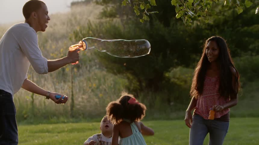 A family blowing bubbles outside