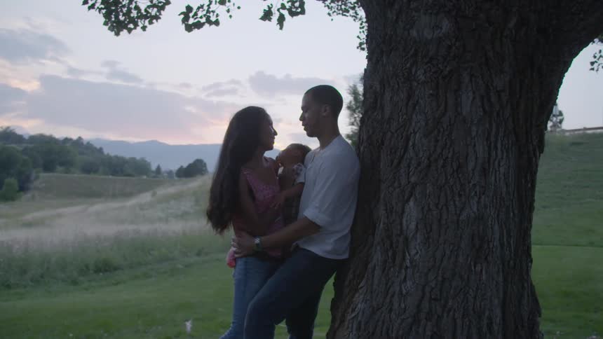 People kissing under a tree