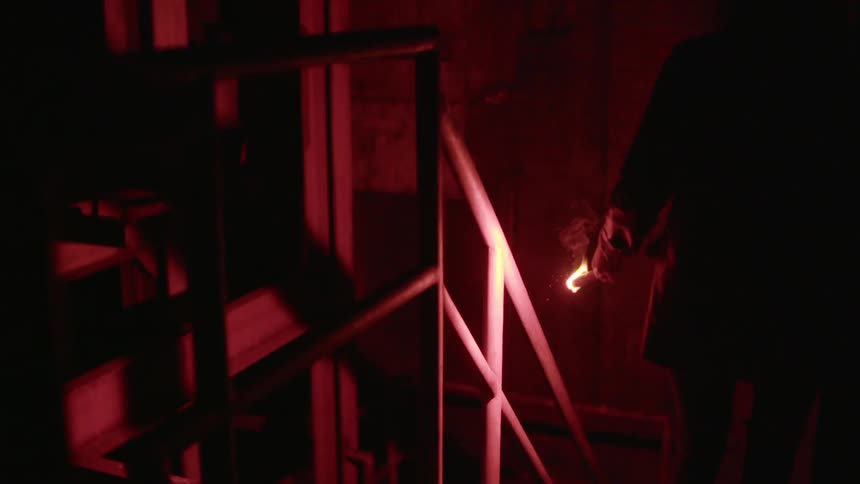 A person using a flare to light their way down the stairs