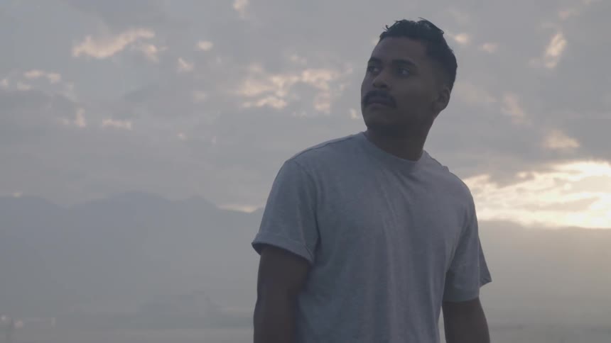 A man with clouds in the background at sunset