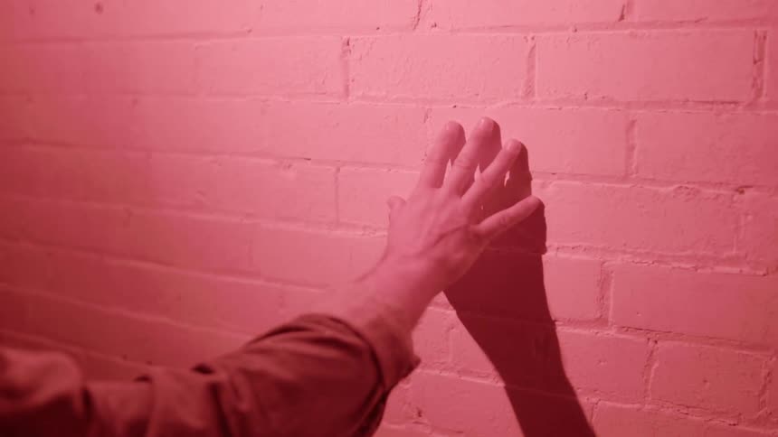 A person touching a wall