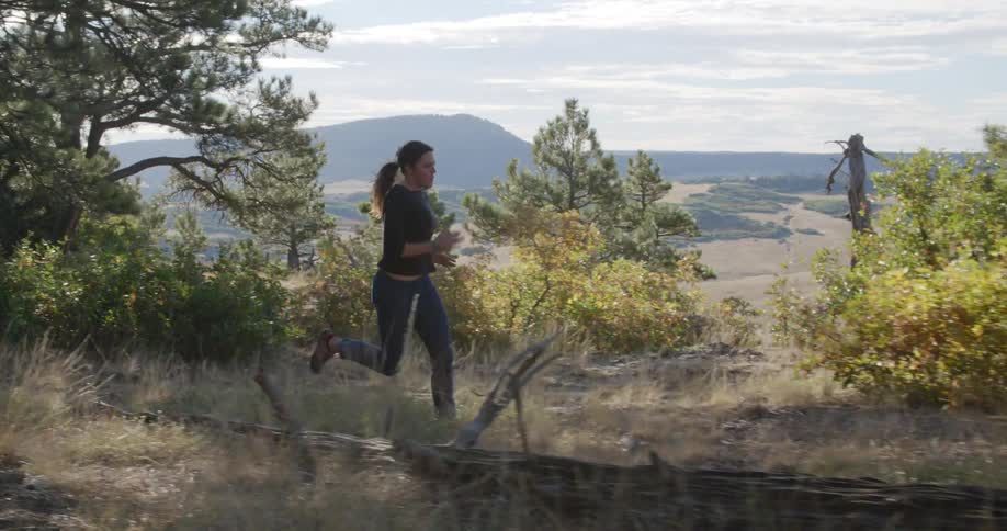 A woman running through a wooded area