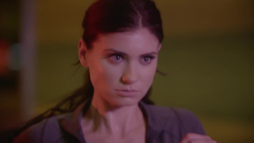 A woman's face showing concentration while jogging