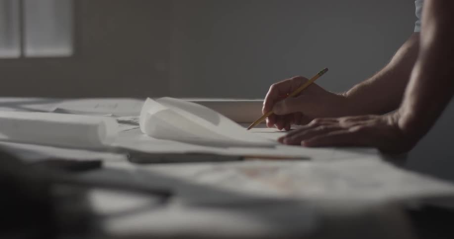 A person that is writing with a pencil on a piece of paper