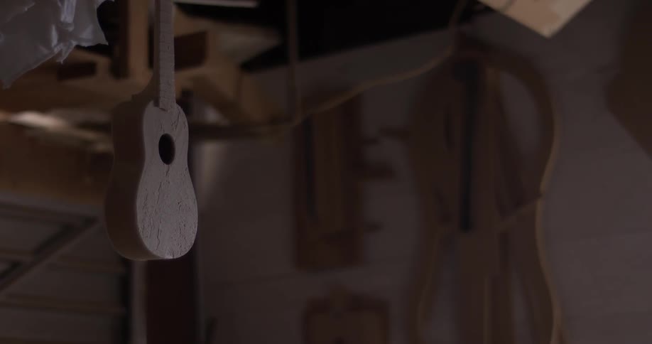 Carpenter Making Guitar In Workshop