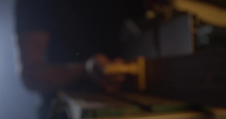 A man sands a piece of lumber