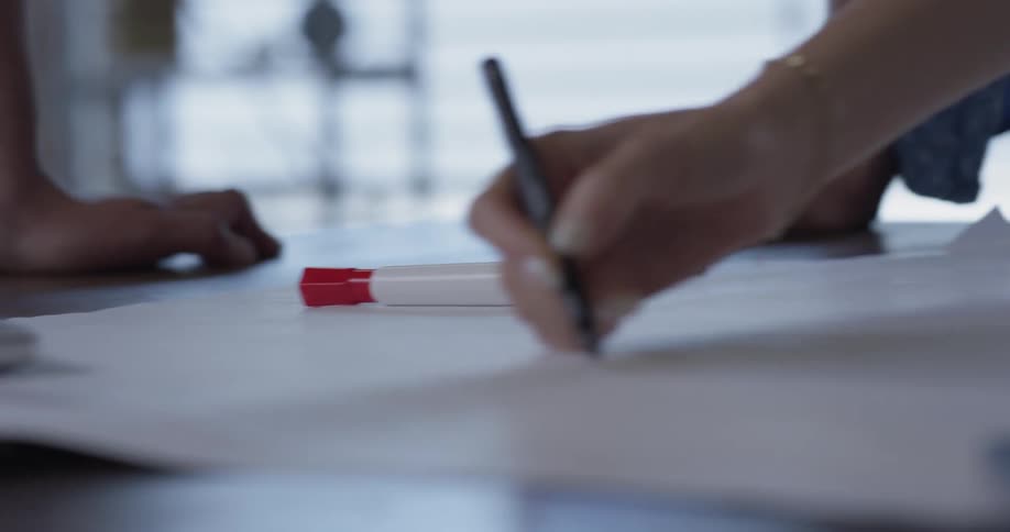A person that is drawing a line on a piece of paper