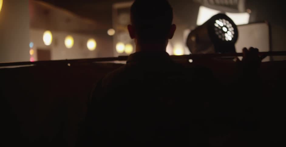 A man setting up a screen on a movie set