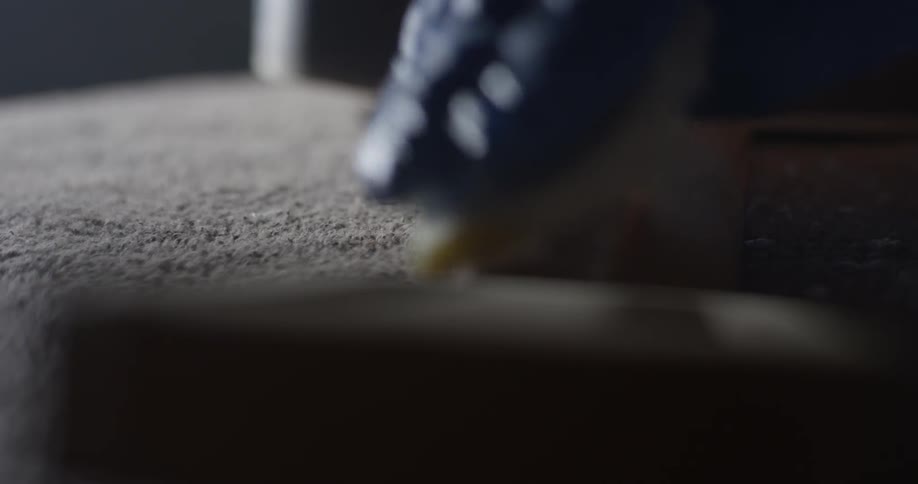 Someone uses a wet sponge to wipe dust from a piece of wood