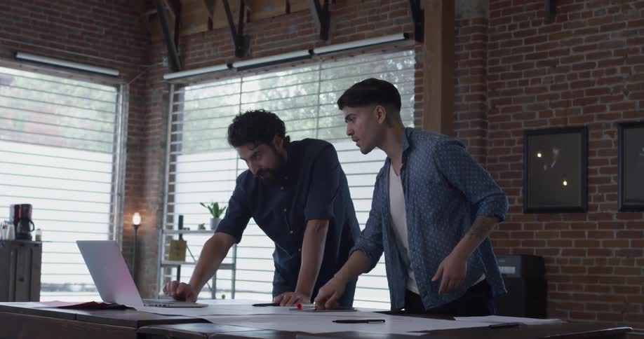 Two men looking at something on a laptop together