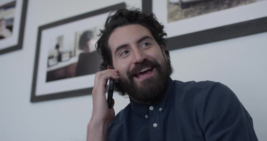 Man picks up and talks on cell phone indoors