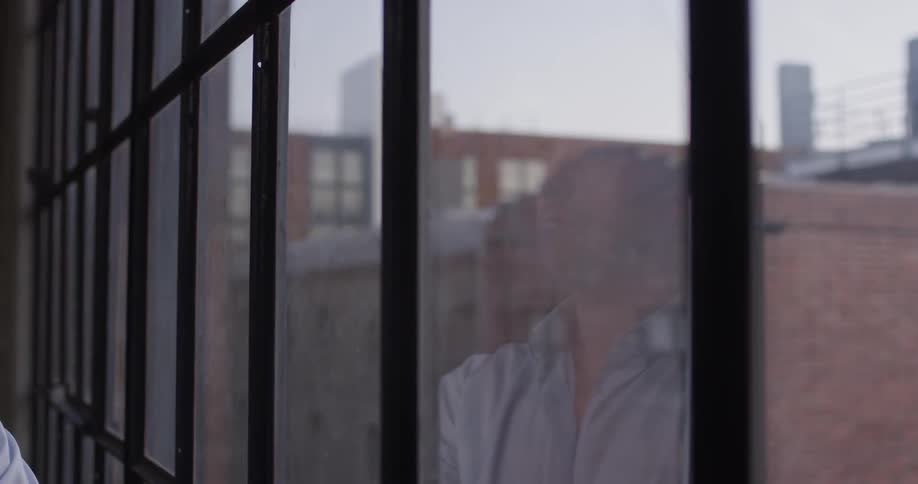 A man looks out a window