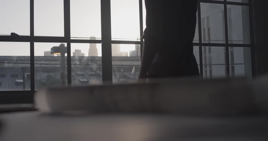 A person walks over to large windows