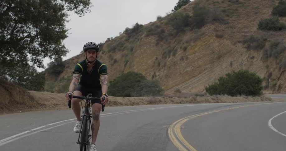 A man riding a bicycle down a mountain road