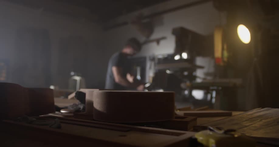 Carpenter Making Guitar In Workshop