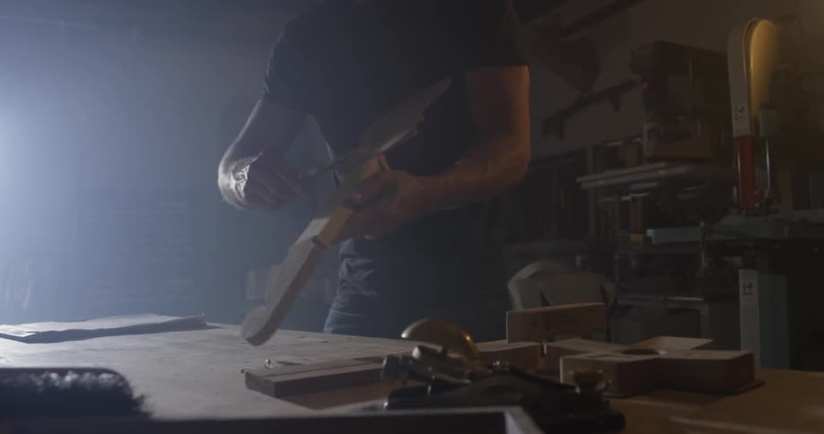 Man works on creating small guitar