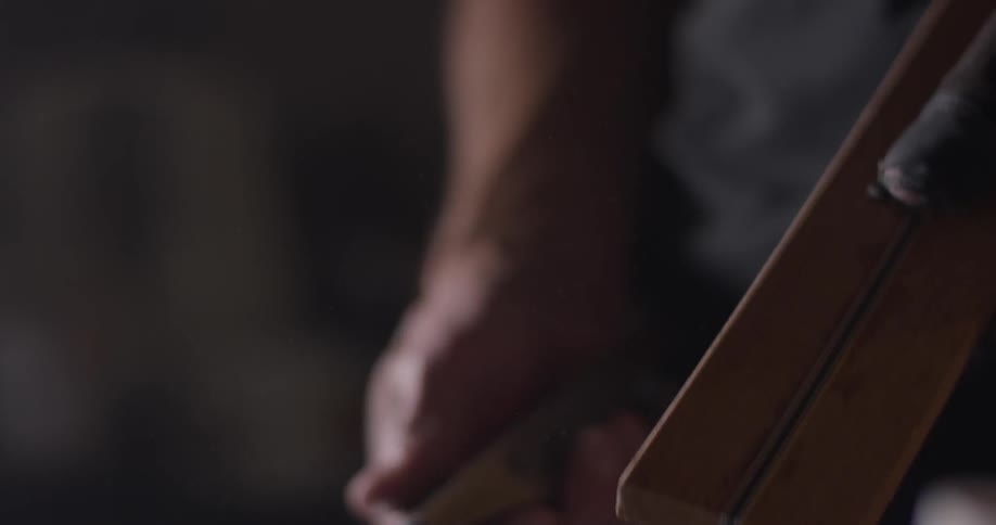 A man rubs a tool with his thumb