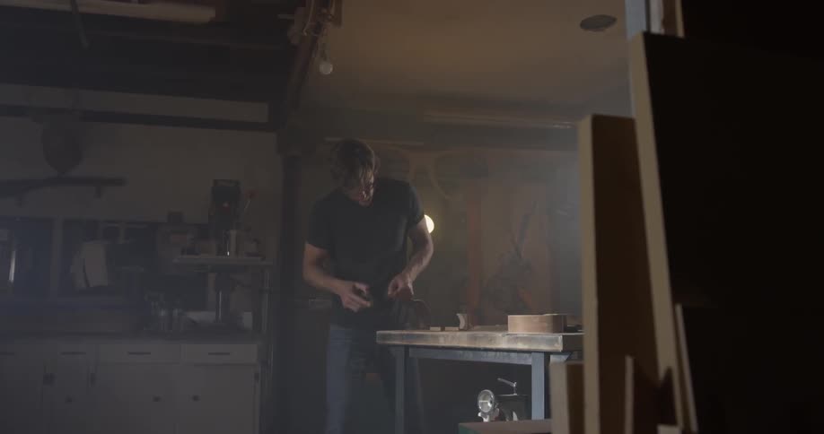 A man is working on a project on a workshop table