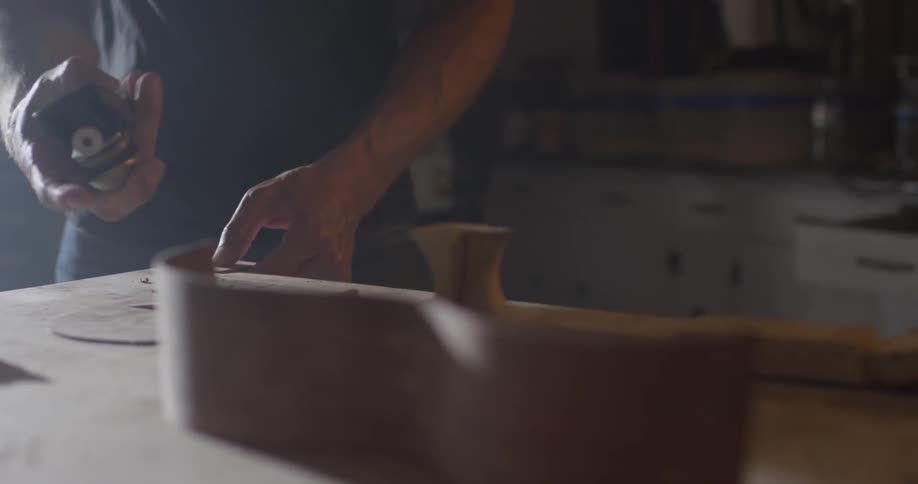 Carpenter Making Guitar In Workshop