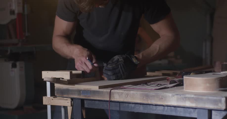 A man is using tools at the table