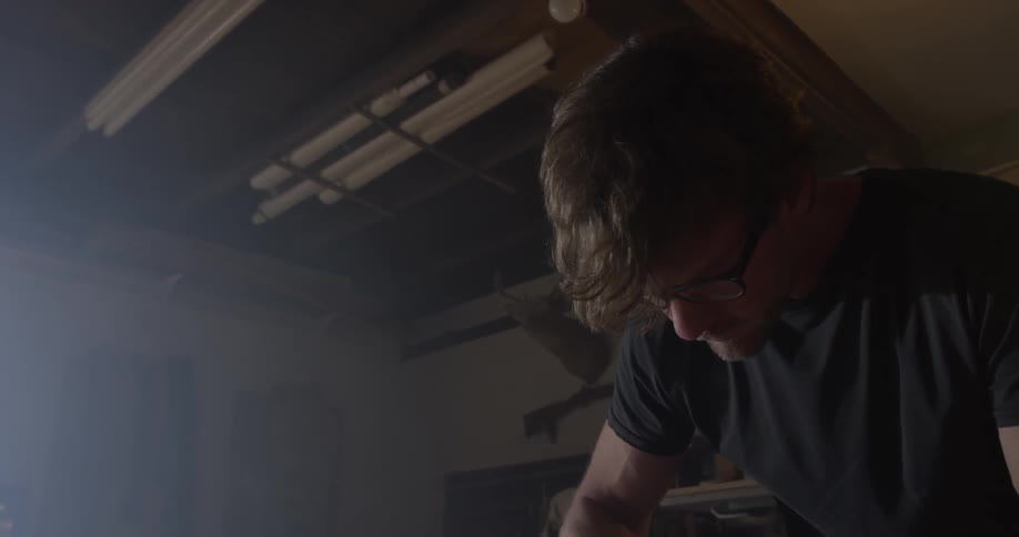 Carpenter Making Guitar In Workshop