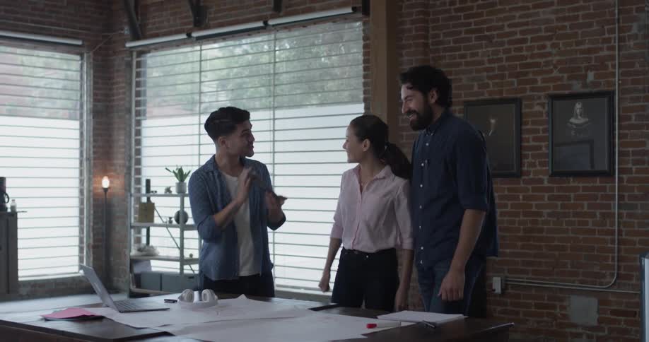 Three people collaborating while looking at a piece of paper in an office