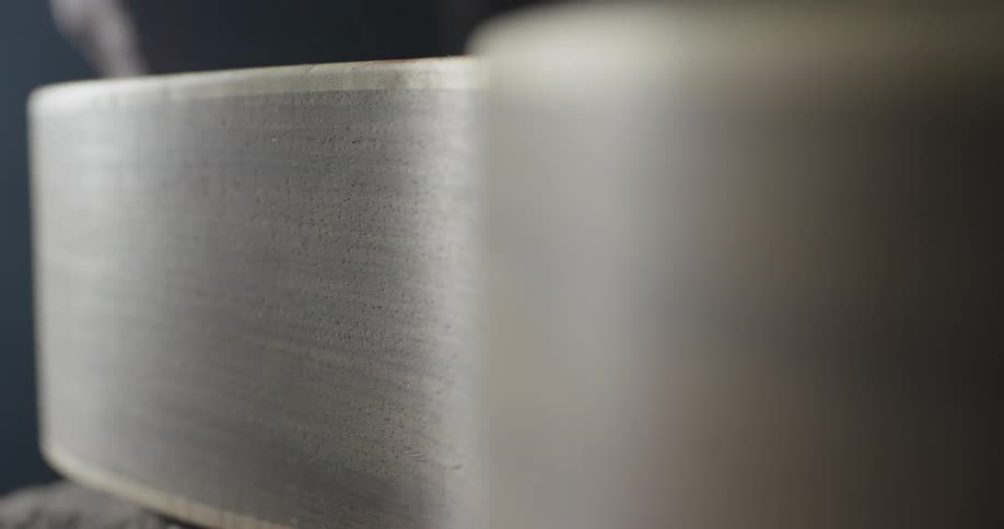 A hand smooths across an object