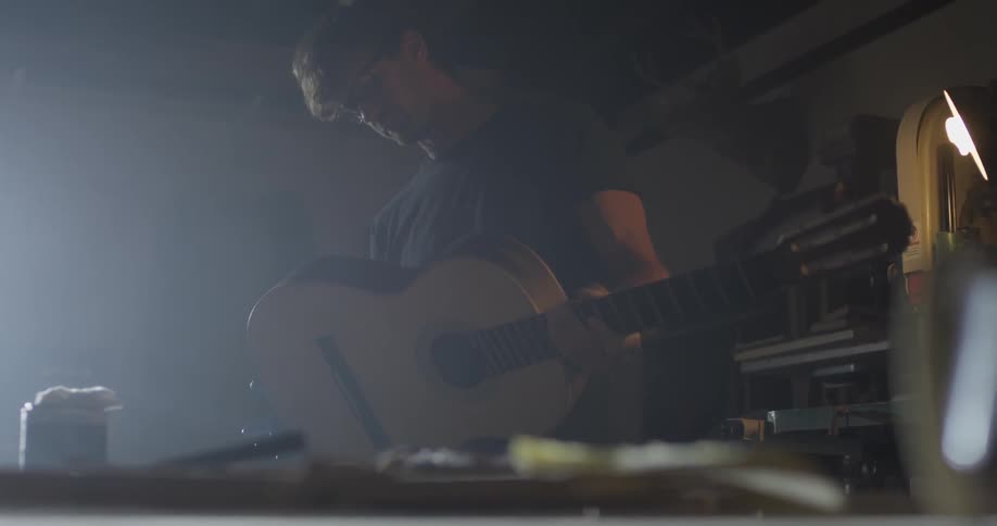Carpenter Making Guitar In Workshop