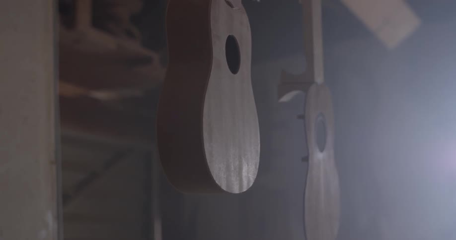 A pair of guitars that are hanging from a rack