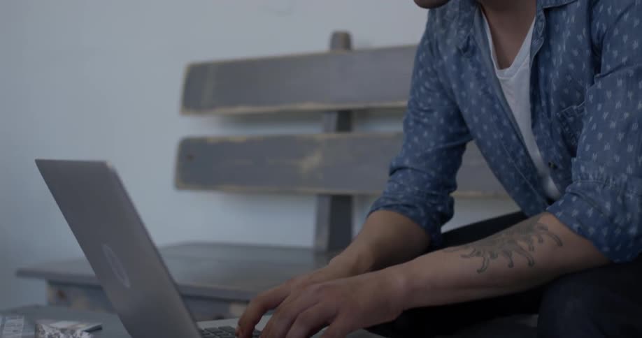 A man that is looking at something on a laptop screen