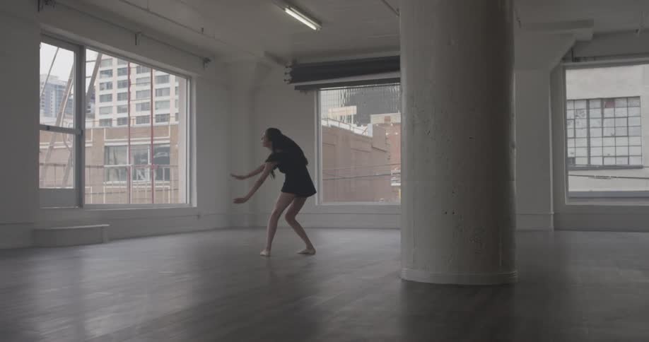 A woman is doing ballet in a room