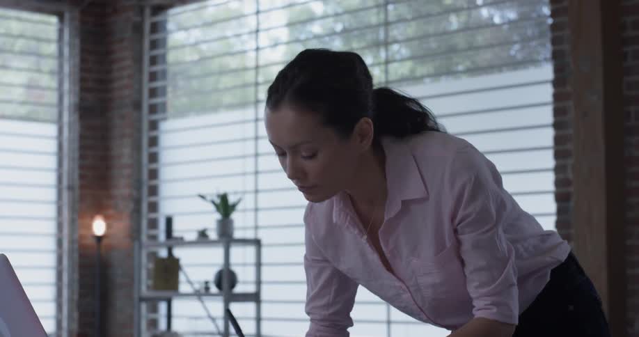 A woman that is standing up and typing on a laptop