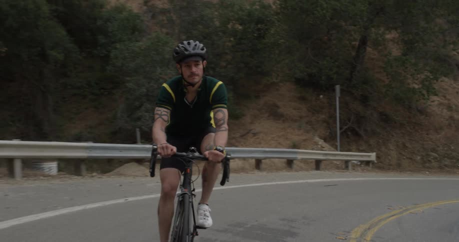 A man riding a bicycle up a mountain road