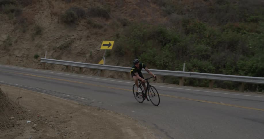A person riding their bike up a deserted road