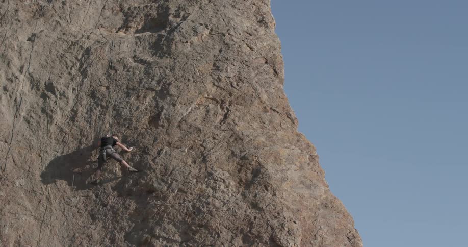 Man scaling the rocky side of a mountain