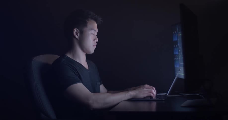 Man Coding On Computer In Dark Room