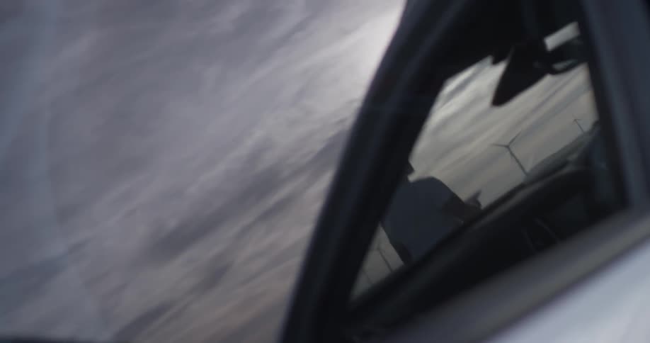 A person that is walking up to a car that is outdoors
