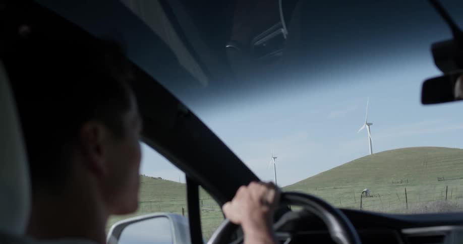A man driving a car around on a dirt road