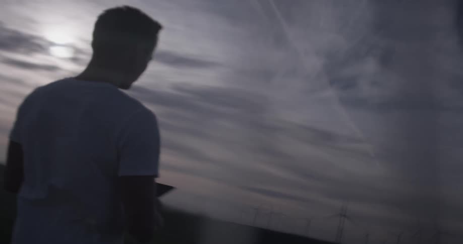 A man is walking holding a tablet